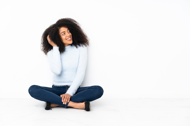 Young african american woman sitting on the floor thinking an idea