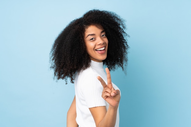 Young african american woman smiling and showing victory sign