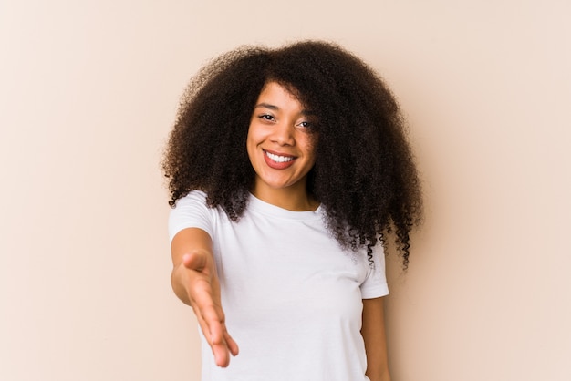 Young african american woman stretching hand in greeting gesture.