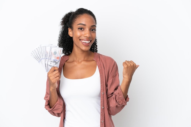 Photo young african american woman taking a lot of money isolated on white background pointing to the side to present a product