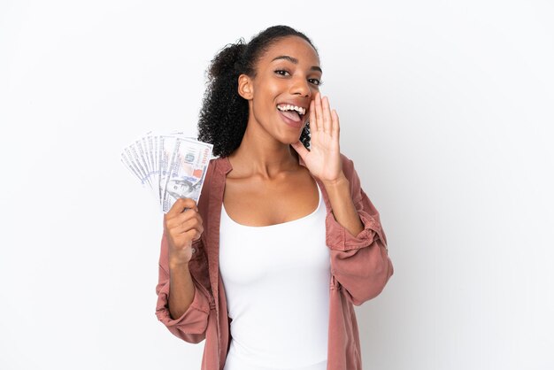 Young African American woman taking a lot of money isolated on white background shouting with mouth wide open