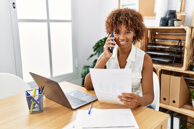 Young african american woman talking on the smartphone working at office