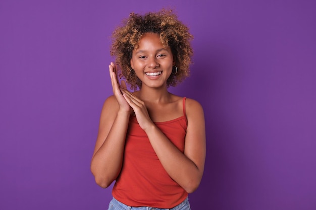 Young african american woman teenager with wide smile applauds stands in studio