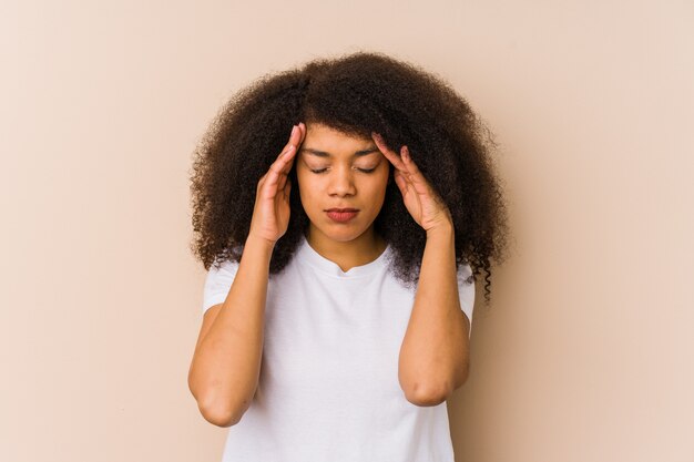 Young african american woman touching temples and having headache.