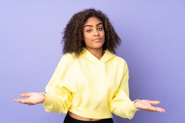 Young African American woman on wall having doubts