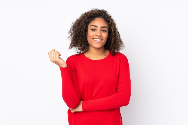 Young African American woman on wall laughing