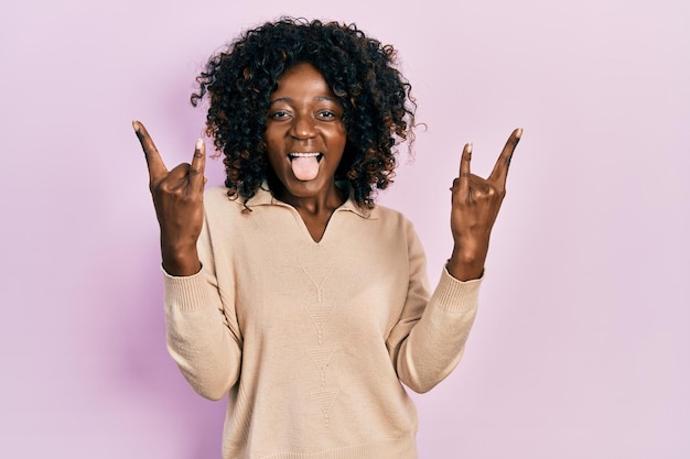 Young african american woman wearing casual clothes shouting with crazy expression doing rock symbol with hands up music star heavy concept