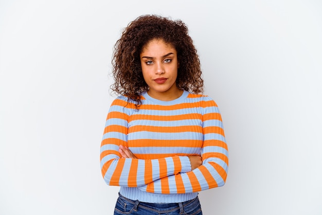 Young african american woman on white frowning face in displeasure, keeps arms folded.