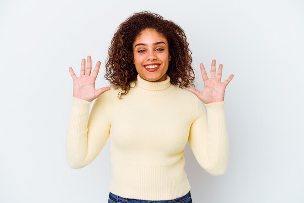 Foto giovane donna afroamericana su bianco che mostra il numero dieci con le mani.