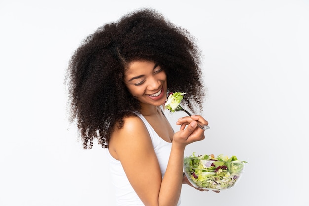 Young african american woman on white wall