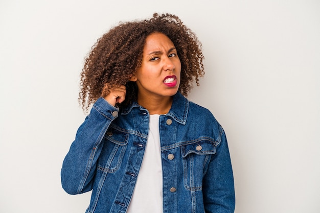 곱슬머리를 가진 젊은 아프리카계 미국인 여성은 흰색 배경에 손가락으로 귀를 덮고 큰 소리로 스트레스를 받고 절망적입니다.