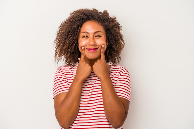 Young african american woman with curly hair isolated on white background doubting between two options.