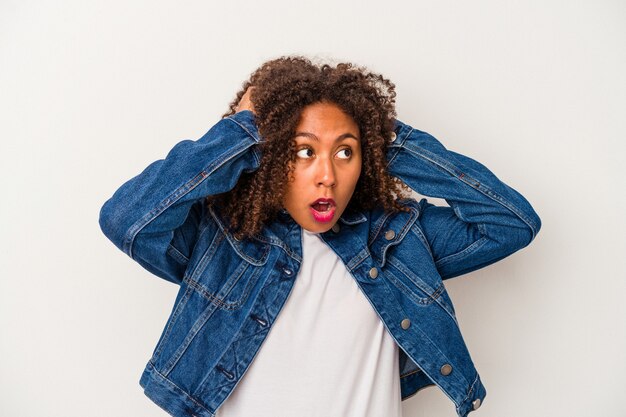 Young african american woman with curly hair isolated on white background screaming, very excited, passionate, satisfied with something.