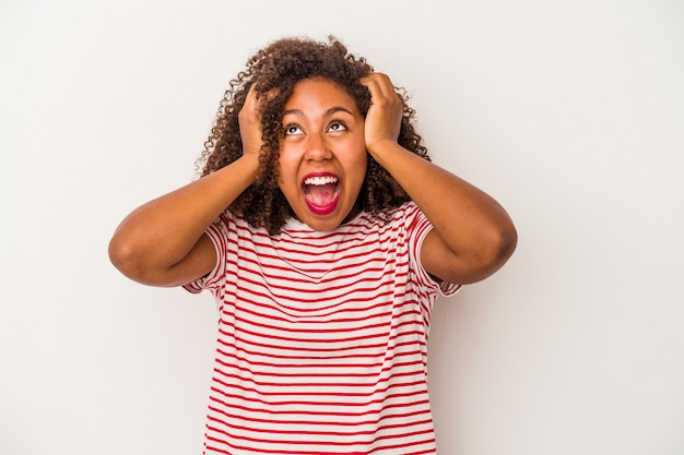 Young african american woman with curly hair isolated on white background screaming, very excited, passionate, satisfied with something.