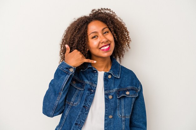 Young african american woman with curly hair isolated on white background showing a mobile phone call gesture with fingers.