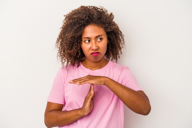 Young african american woman with curly hair isolated on white background showing a timeout gesture.