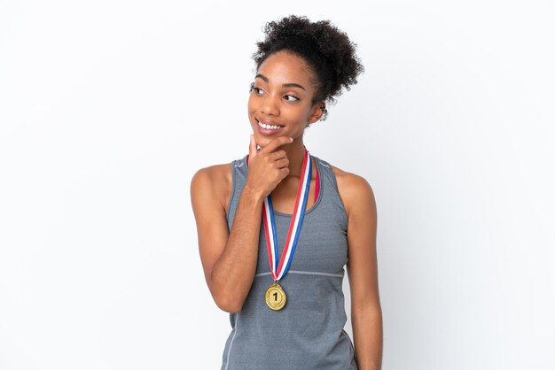 Young African American woman with medals isolated on white background looking to the side