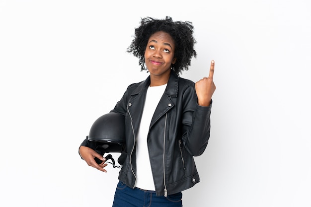 Young African American woman with a motorcycle helmet on white wall pointing with the index finger a great idea