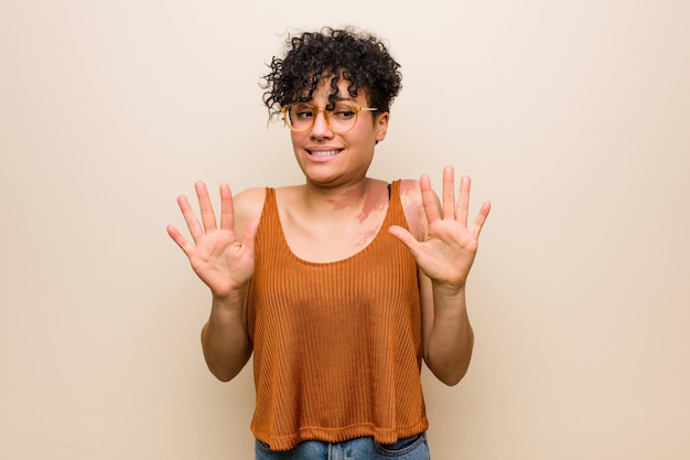 写真 嫌悪のジェスチャーを示す誰かを拒否する皮膚のあざを持つ若いアフリカ系アメリカ人女性。