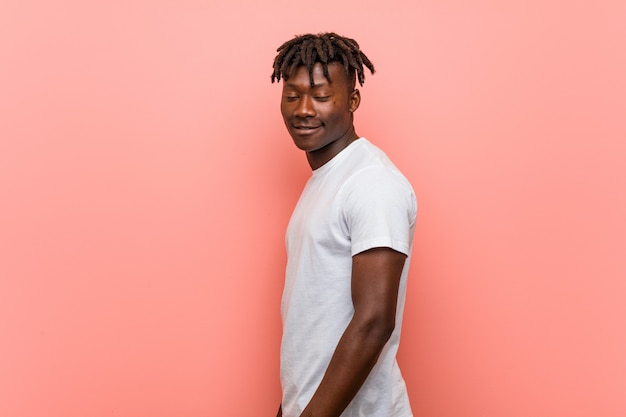 Young african black man looks aside smiling, cheerful and pleasant.