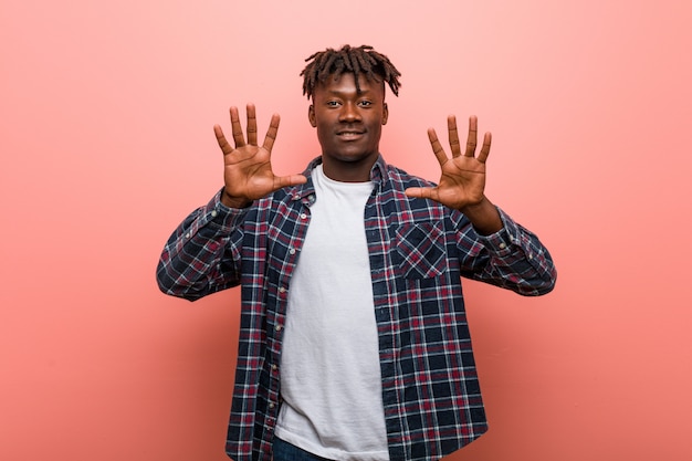 Young african black man showing number ten with hands.