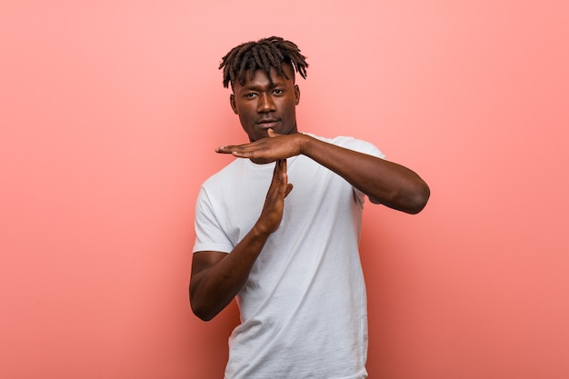 Young african black man showing a timeout gesture.