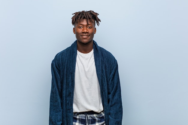 Young african black man wearing pajama happy, smiling and cheerful.