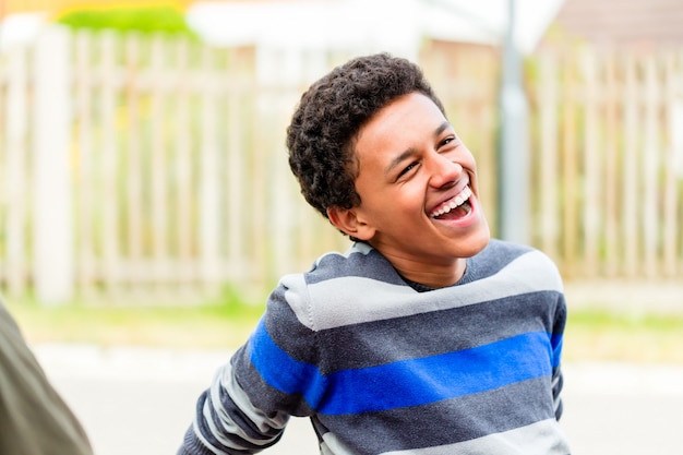 Young African boy sitting on floor in garden