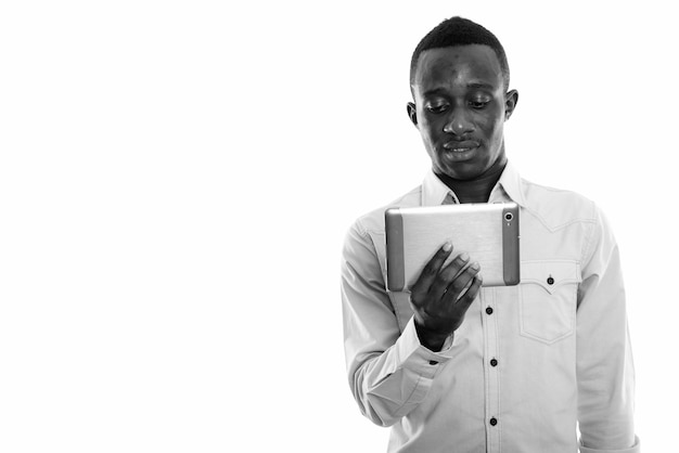  young African businessman isolated against white wall in black and white