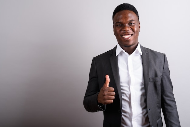 young African businessman wearing suit against white space