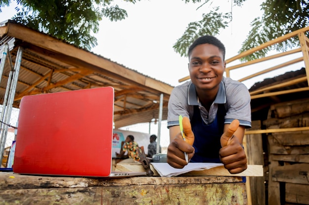 Photo young african carpenter standing holding working calling laptop