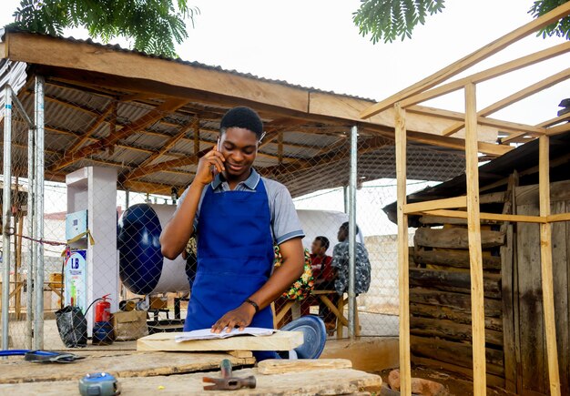 Photo young african carpenter standing holding working calling