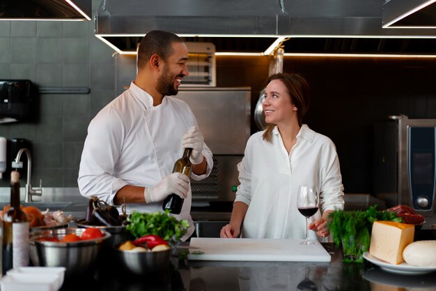 Foto il giovane chef africano sta cucinando insieme alla ragazza caucasica in cucina