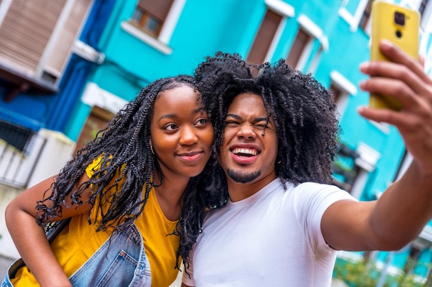 Young african couple pulling faces taking selfie int he city