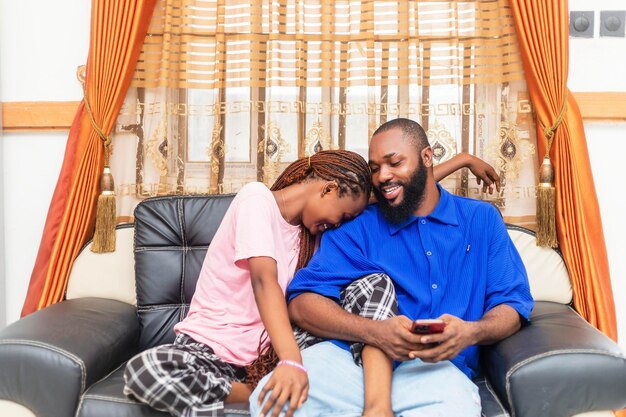 Photo young african couple using mobile on couch