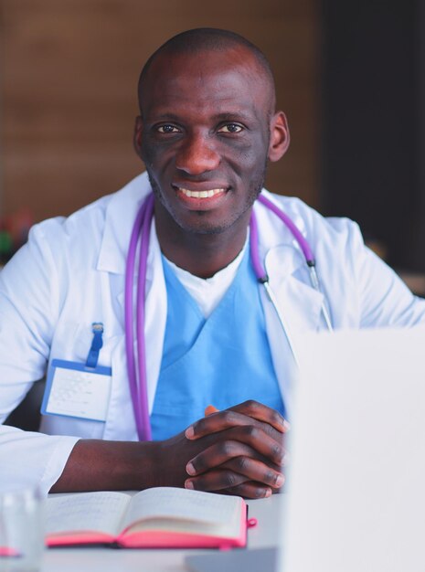 Young african doctor working on laptop at desk Doctor Workplace