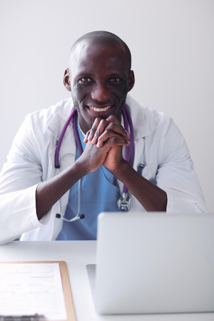 Young african doctor working on laptop at desk