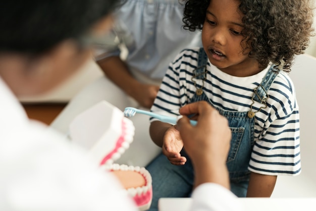 Photo young african kid with a dentist