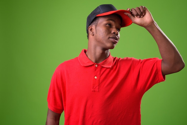 Young African man against green wall