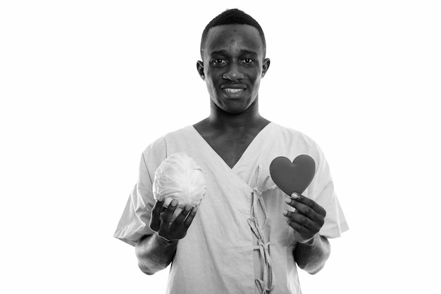  young African man as hospital patient isolated against white wall in black and white