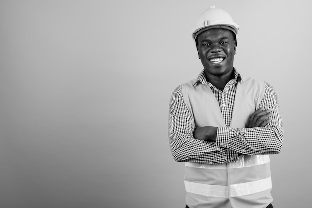 young African man construction worker against white wall. black and white