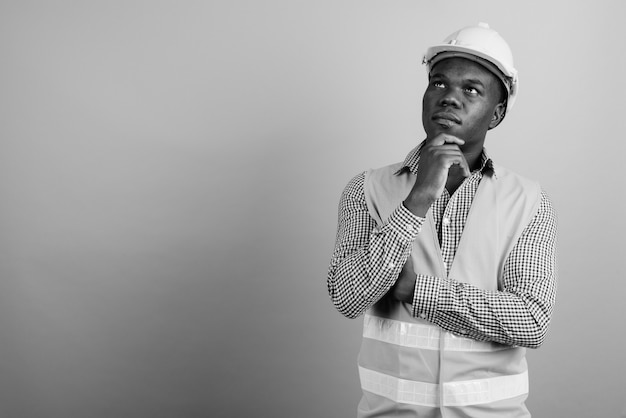 young African man construction worker against white wall. black and white