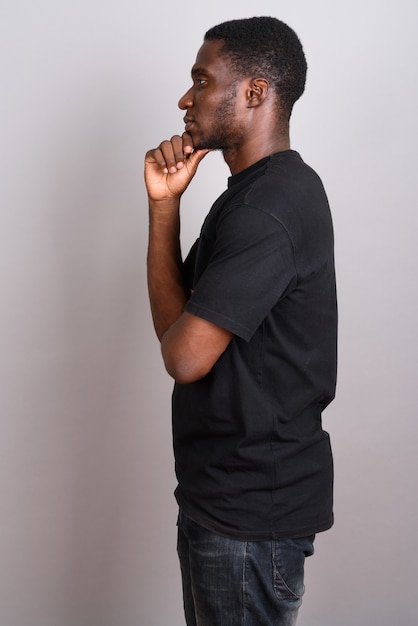 Young African man wearing black shirt on gray