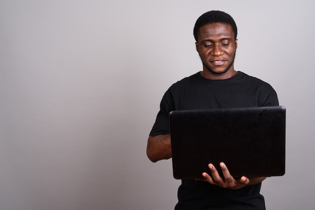 Young African man wearing black shirt on gray