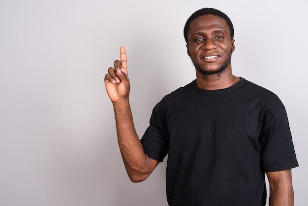 Young African man wearing black shirt on gray