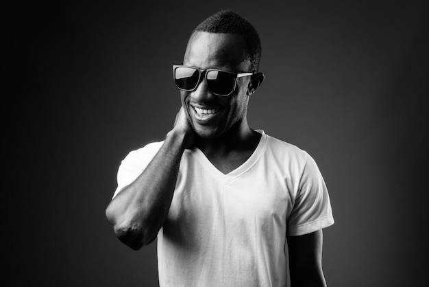 Young African man wearing sunglasses and laughing