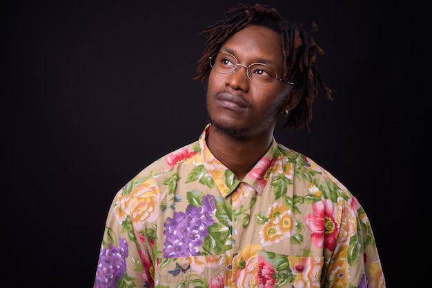 young African man with dreadlocks on black