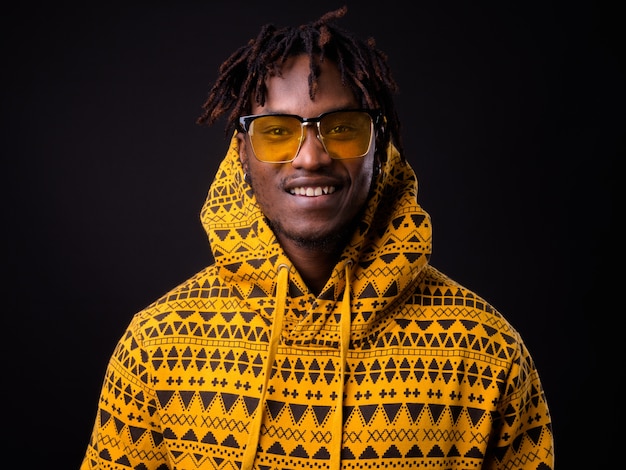 young African man with dreadlocks on black