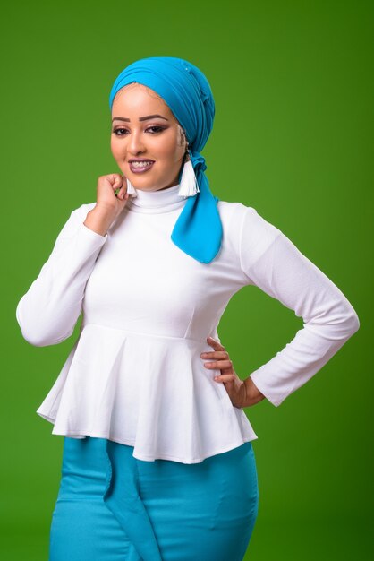 Young African Muslim woman against chroma key with green wall