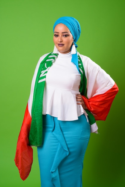 Young African Muslim woman against chroma key with green wall